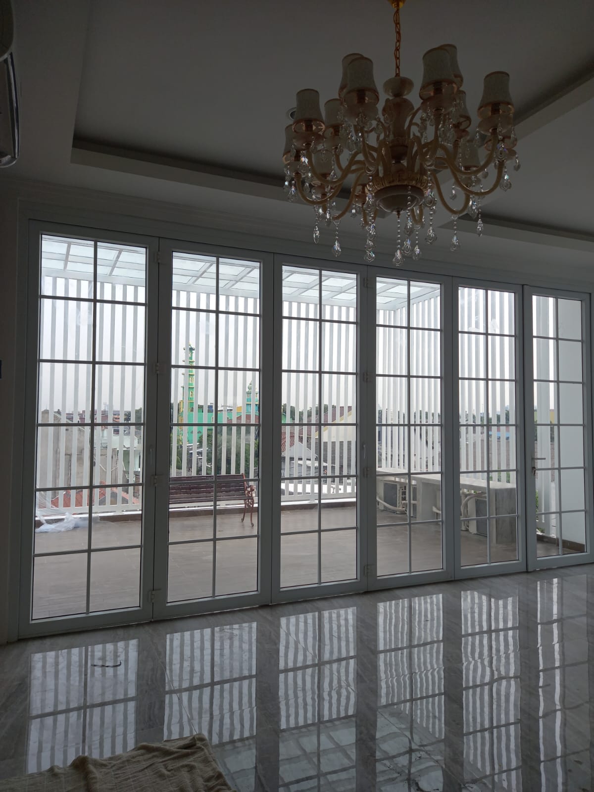 Panel kaca berpola kotak pada akses menuju balkon.